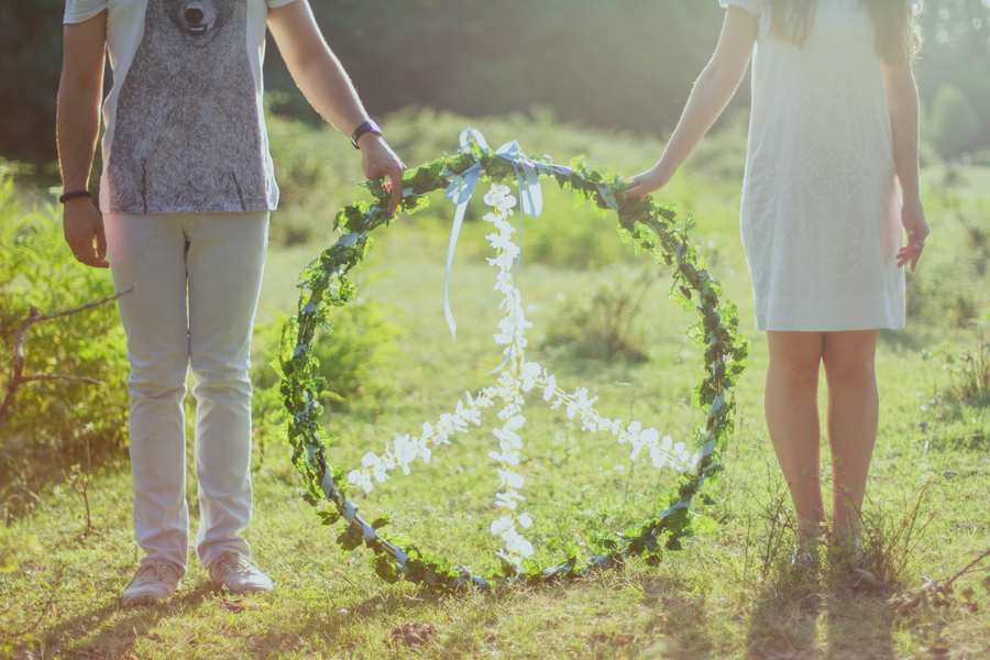 Dos personas, una al lado de la otra, sostienen un gran signo de la paz circular, hecho de hojas verdes y flores blancas, que simboliza la esperanza y la armonía, al igual que la mediación familiar en caso de divorcio se esfuerza por lograr el entendimiento en tiempos difíciles. Dos personas, una al lado de la otra, sostienen un gran signo de la paz circular, hecho de hojas verdes y flores blancas, que simboliza la esperanza y la armonía, al igual que la mediación familiar en caso de divorcio se esfuerza por lograr el entendimiento en tiempos difíciles.