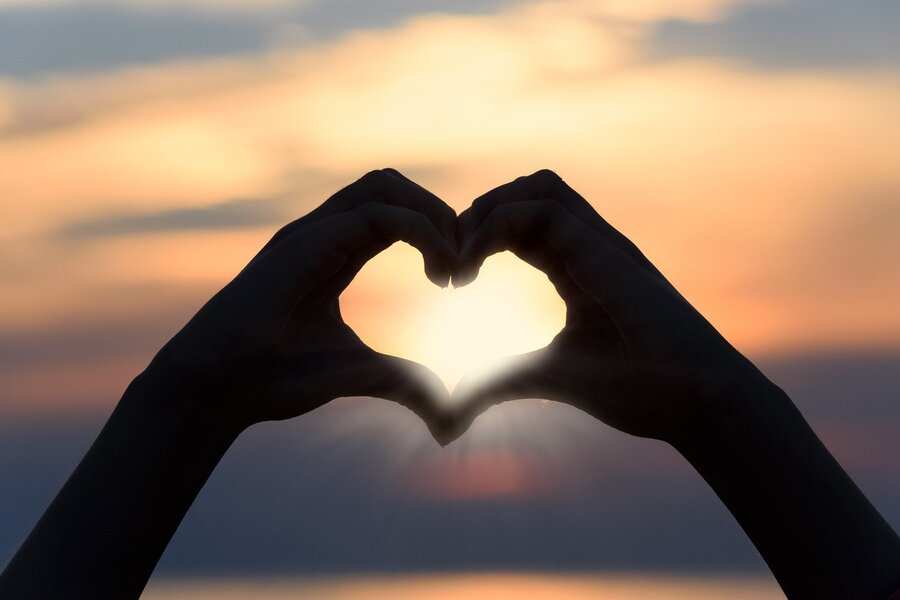 Dos manos forman la forma de un corazón con los dedos y los pulgares, enmarcando la puesta de sol contra un cielo borroso naranja y amarillo, símbolo de nuevos comienzos, igual que el proceso de cómo hacerse pareja de hecho. Dos manos forman la forma de un corazón con los dedos y los pulgares, enmarcando la puesta de sol contra un cielo borroso naranja y amarillo, símbolo de nuevos comienzos, igual que el proceso de cómo hacerse pareja de hecho.