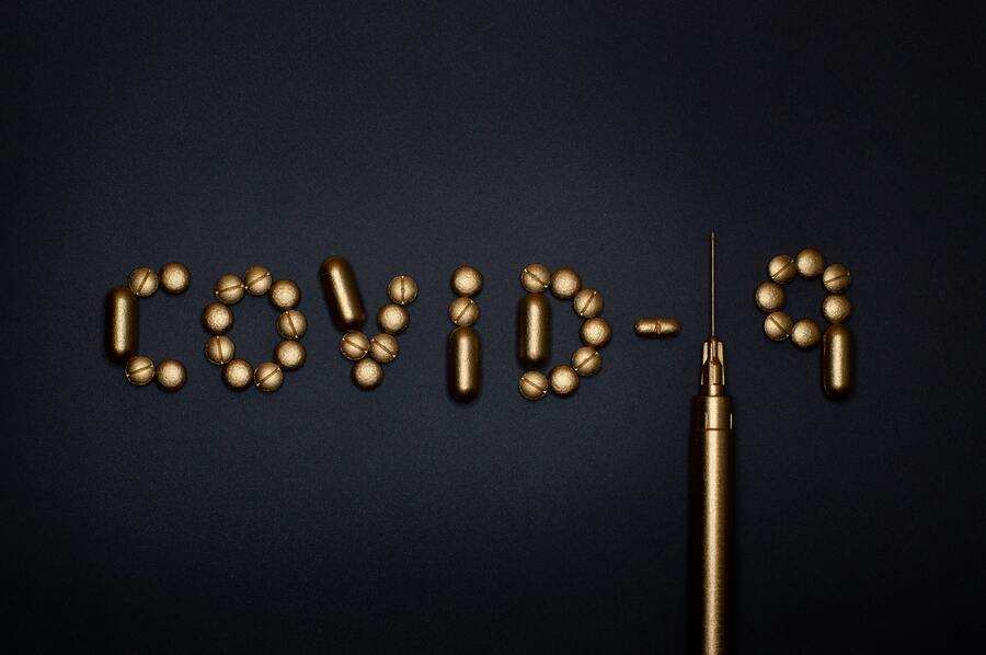 Unas pastillas doradas y una jeringuilla forman «COVID-19» sobre una superficie oscura, simbolizando el desacuerdo de vacunar a los hijos cuando las familias se enfrentan a opiniones divergentes sobre la vacunación infantil. Unas pastillas doradas y una jeringuilla forman "COVID-19" sobre una superficie oscura, simbolizando el desacuerdo de vacunar a los hijos cuando las familias se enfrentan a opiniones divergentes sobre la vacunación infantil.