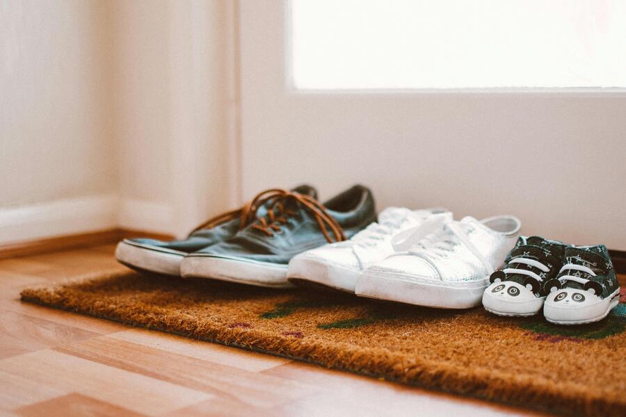 Tres pares de zapatos -un par de zapatillas de adulto marrones oscuras, unas zapatillas de adulto blancas y unos zapatitos de bebé blancos y negros- están colocados ordenadamente en un felpudo junto a la puerta, reflejando un hogar cálido donde alguien puede estar pensando en adoptar al hijo de mi pareja. Tres pares de zapatos -un par de zapatillas de adulto marrones oscuras, unas zapatillas de adulto blancas y unos zapatitos de bebé blancos y negros- están colocados ordenadamente en un felpudo junto a la puerta, reflejando un hogar cálido donde alguien puede estar pensando en adoptar al hijo de mi pareja.